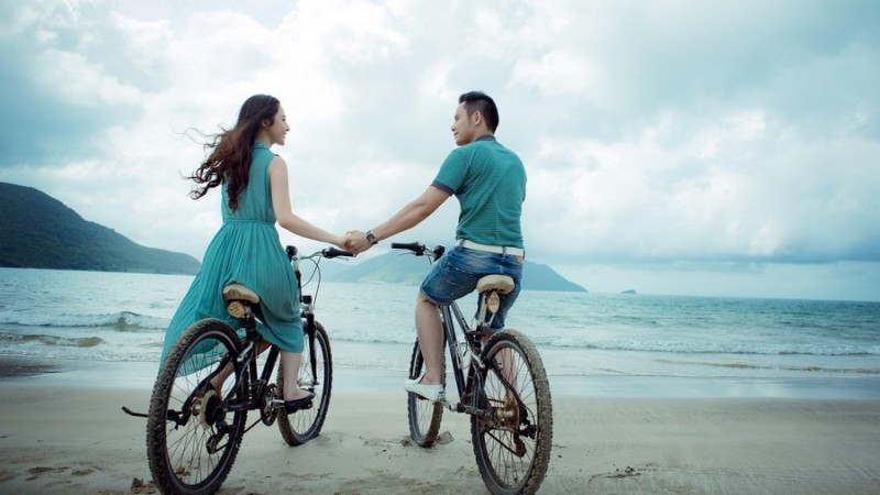 Пара на велосипедах на побережье моря